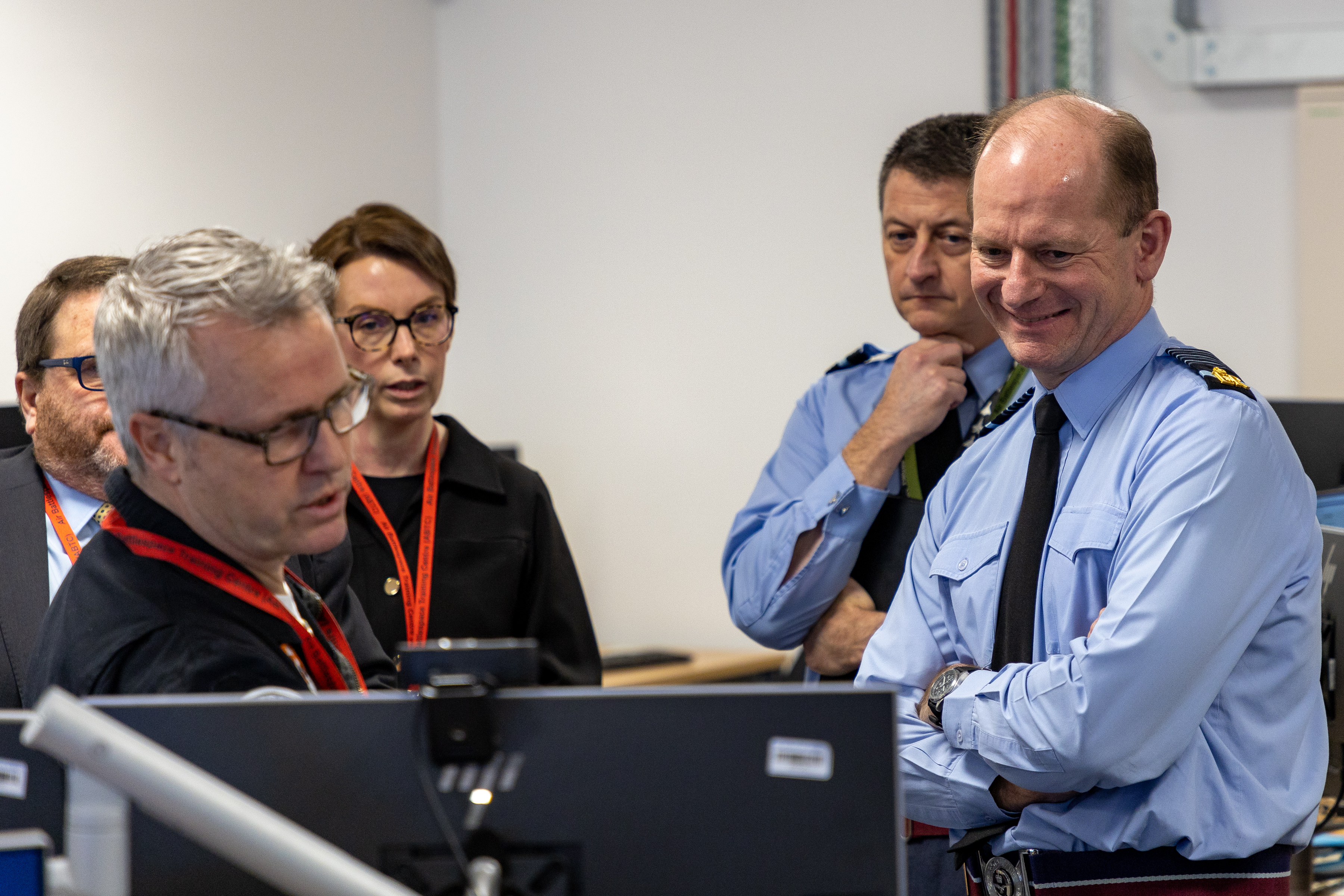 Image shows the Chief of the Air Staff with RAF aviators and civilians looking at desktop computers.